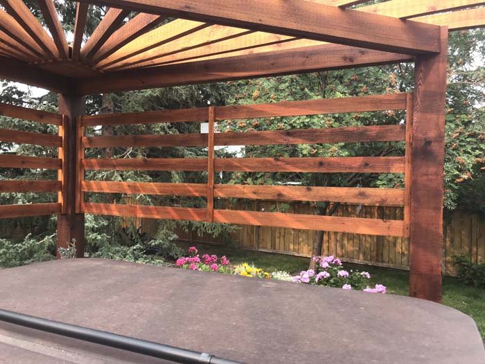 Cedar pergola with a privacy screen in a backyard